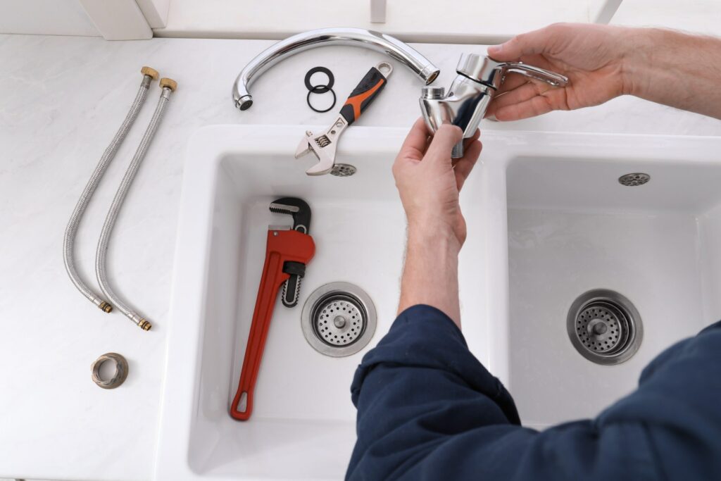 Plumber Fixing A Faucet