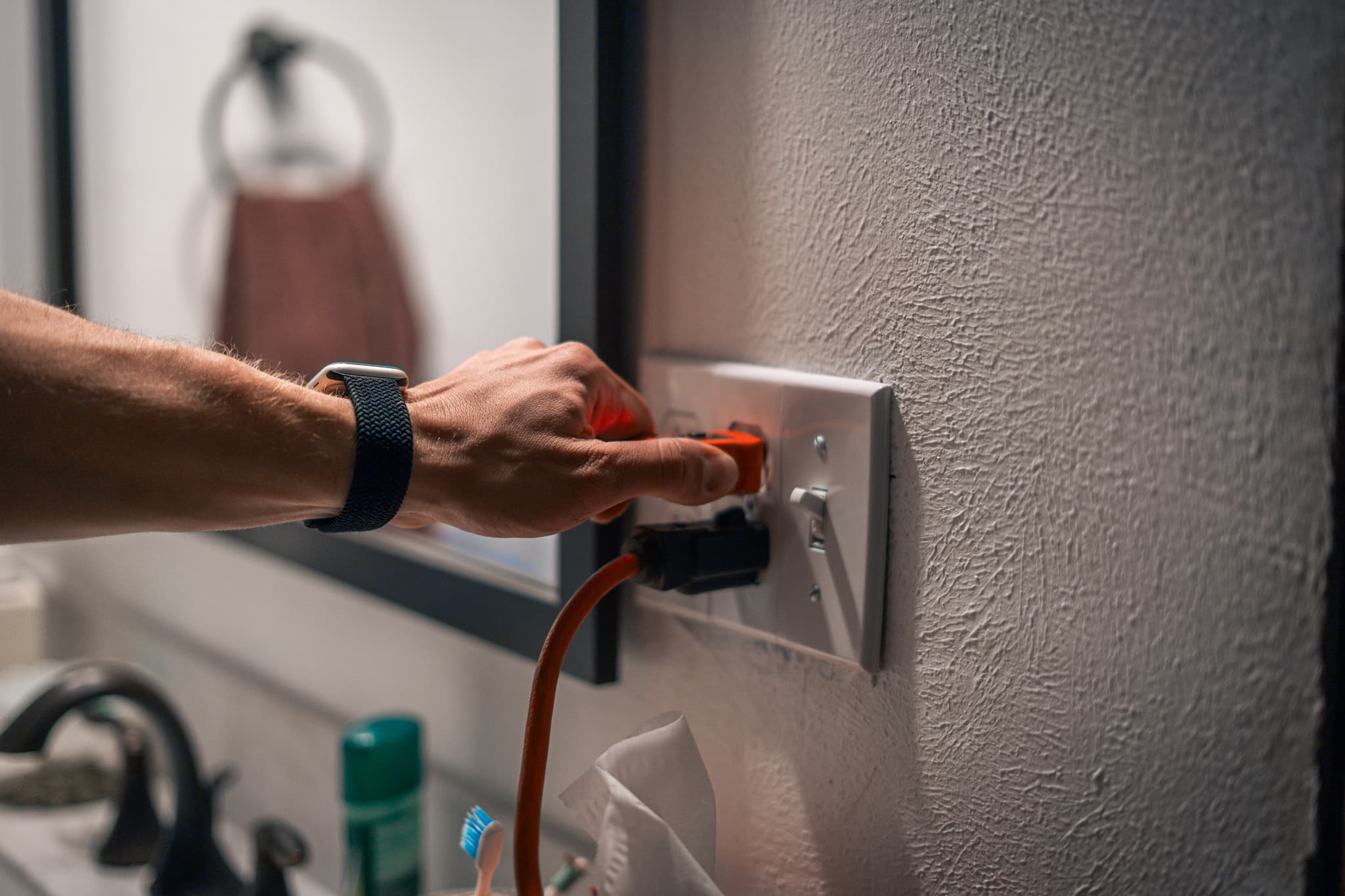 Electrician diagnosing wiring connected to an electrical outlet in an Austell home
